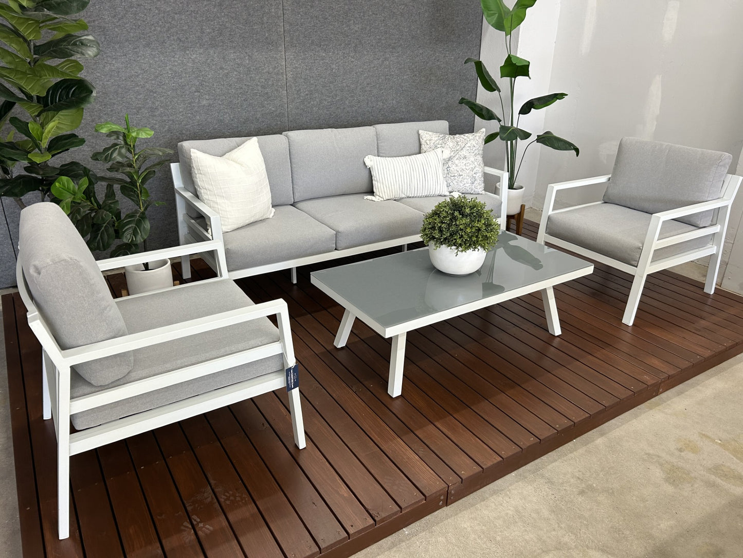 Outdoor sofa setting made of white aluminium frame with grey cushions and tempered glass top coffee table