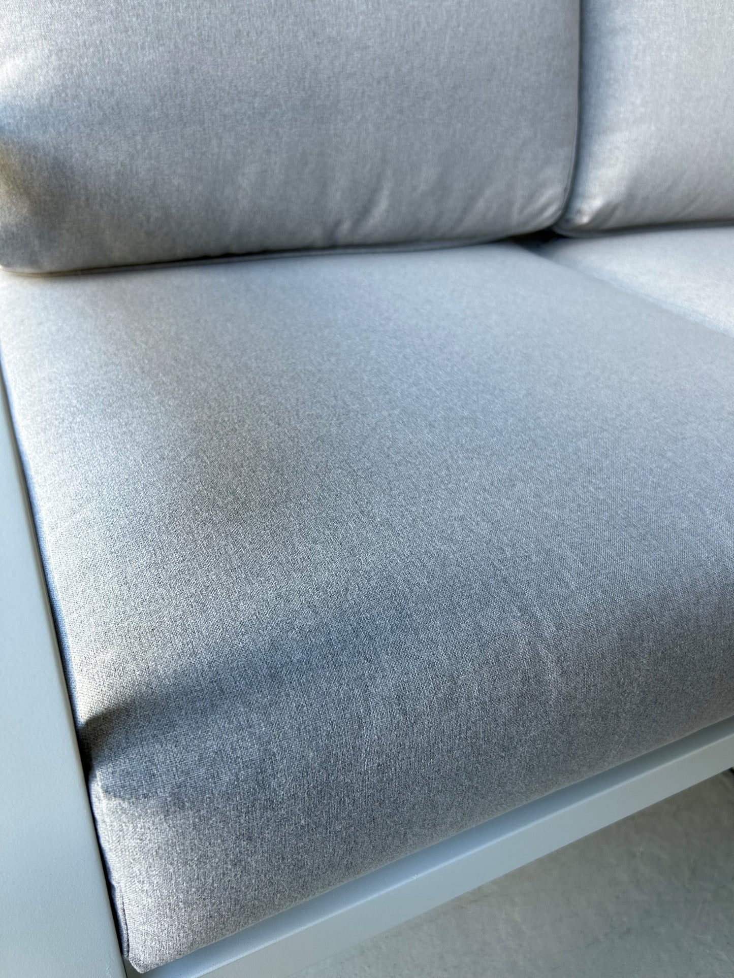 Close up of grey fabric cushion seat on an outdoor sofa setting