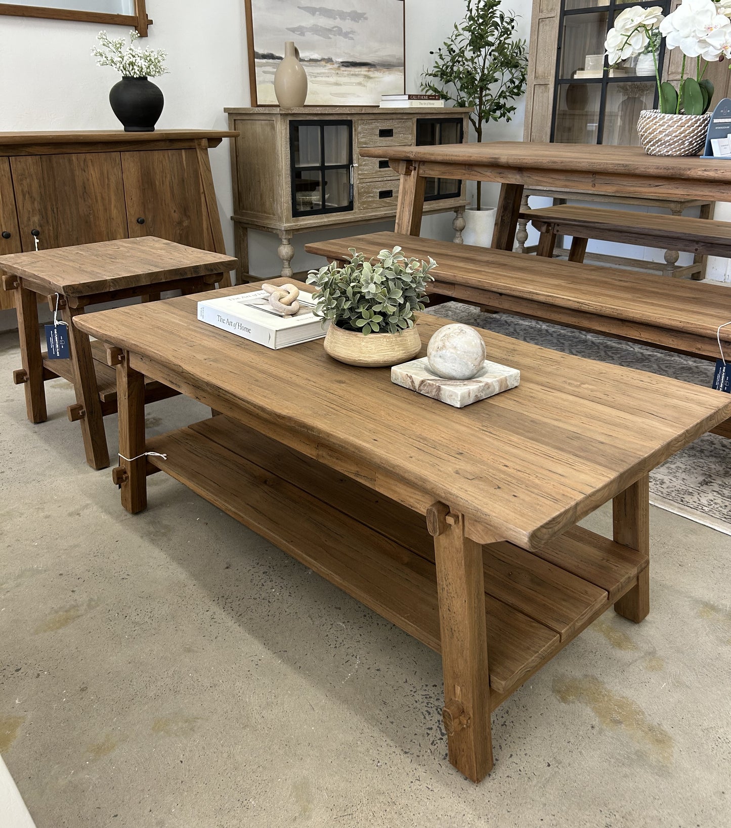 Small farmhouse style coffee table made of dark teak wood with trestle legs and storage