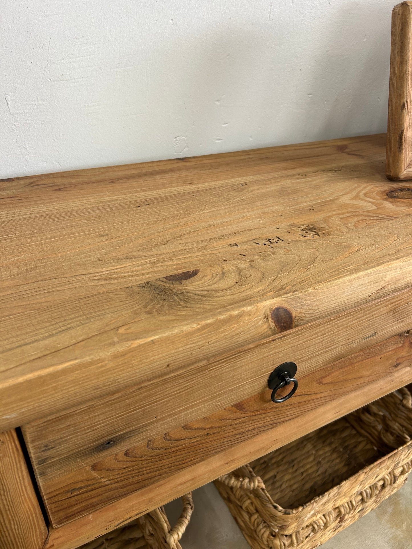 Close up of reclaimed pine wood hall table with rustic wooden details and black metal handles