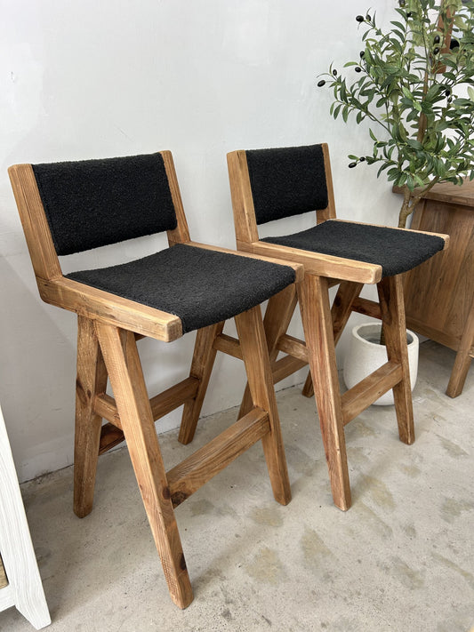 Rustic wooden bar stool with black boucle fabric seat and backrest