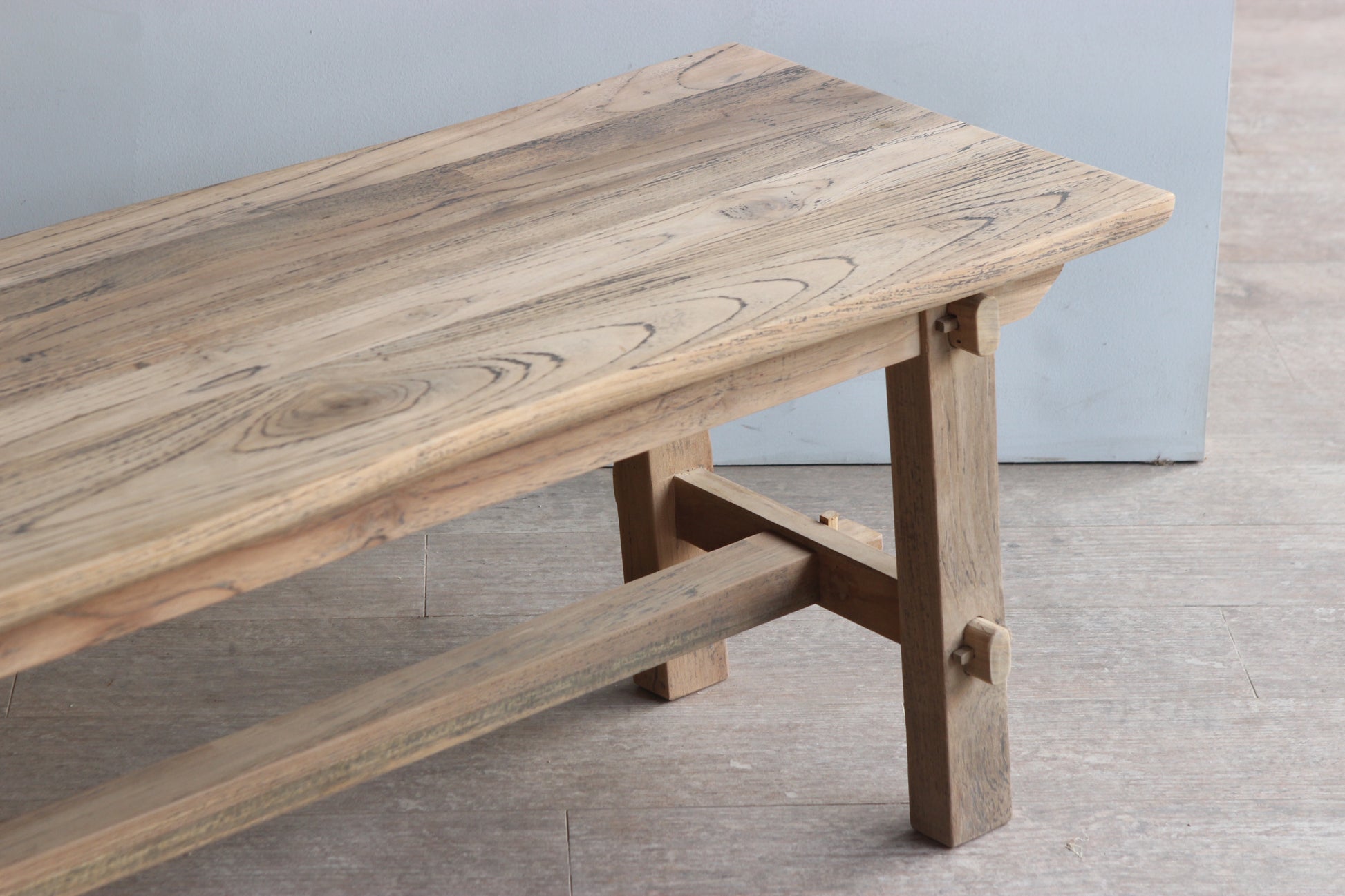 Close up of teak wooden bench seat with trestle legs