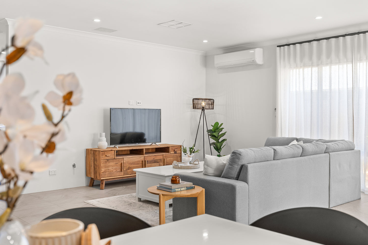 Wooden farmhouse style TV Unit in a modern home creating beautiful contrast against a white wall